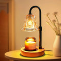 Flower-shaped glass candle warmer lamp glowing above a jar candle