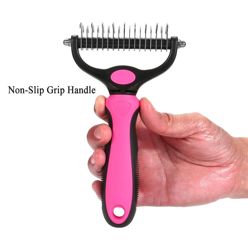Pink pet grooming rake held upright to show its size in a hand