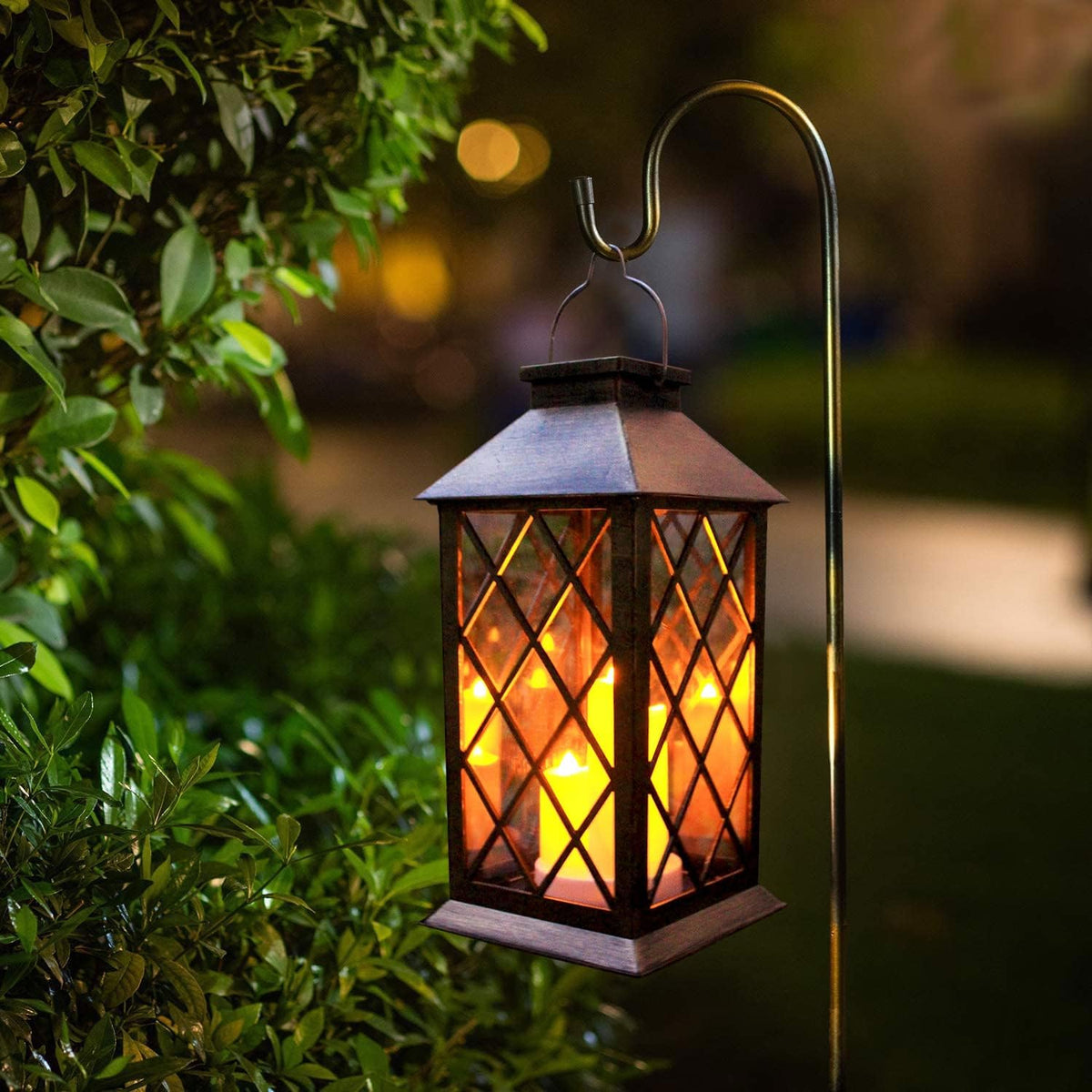 Glowing lantern suspended from a curved garden hanger