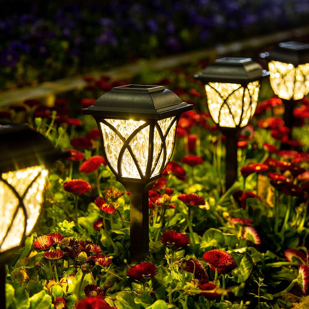 Warm white pathway lights illuminating a flower garden at night