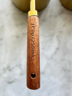Close-up of a wooden measuring cup handle marked 1 cup and 250 mL