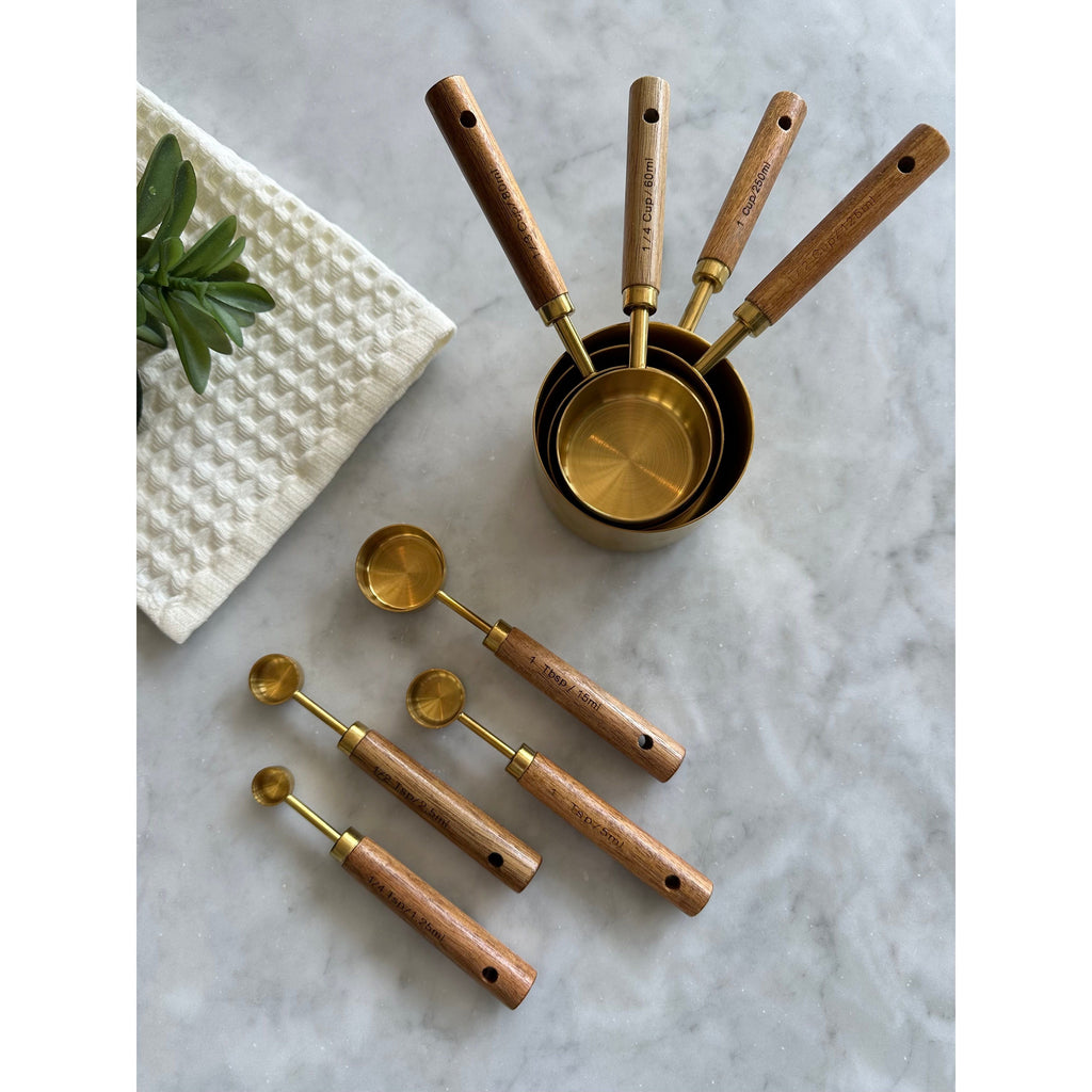 Nested gold measuring cups and four matching wood-handled spoons