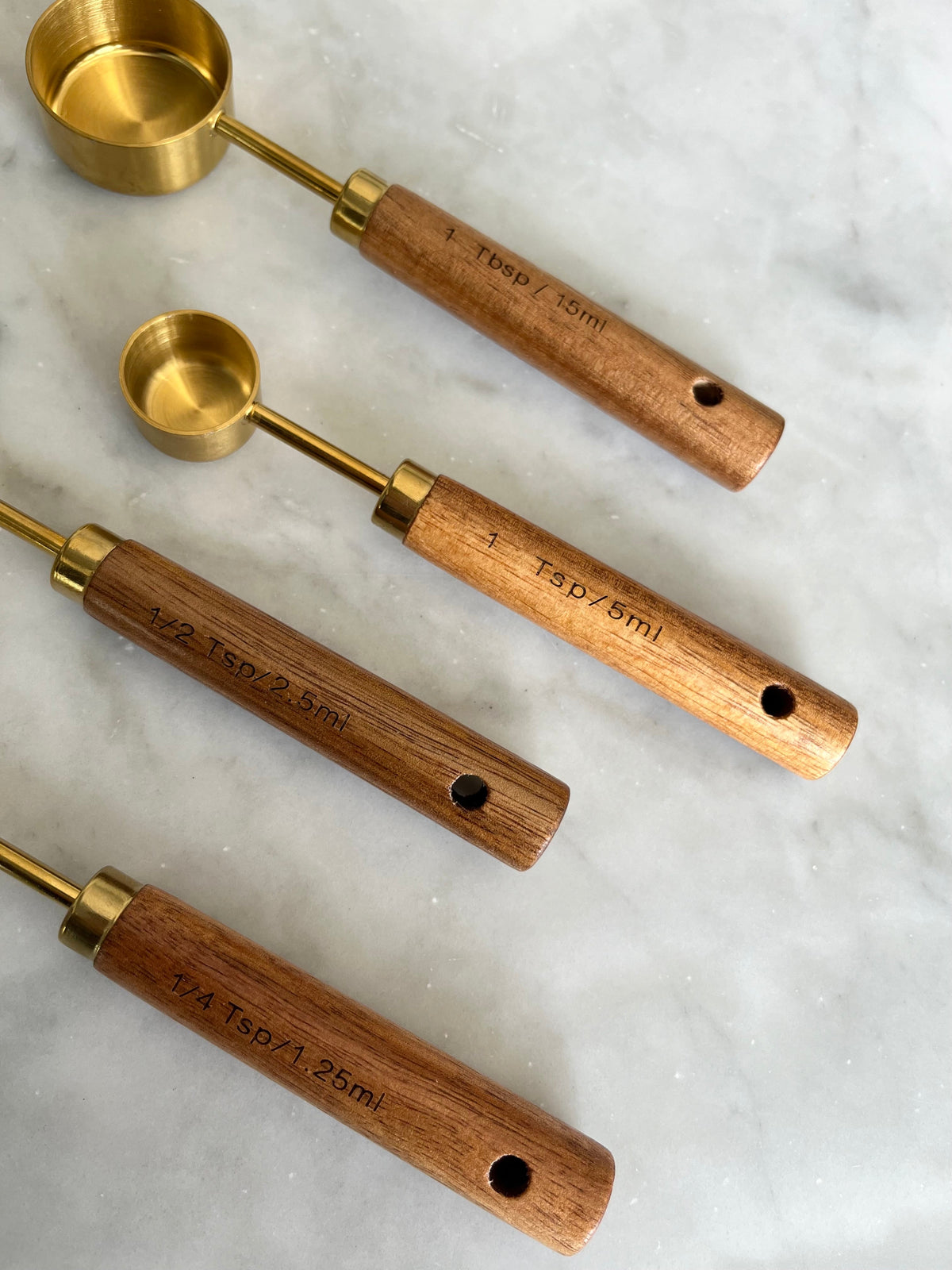 Close-up of capacity markings on wooden measuring spoon handles