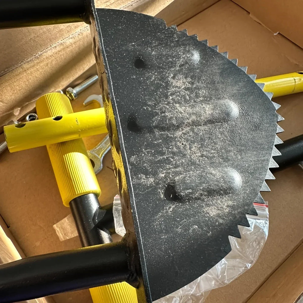 Close-up of a serrated half-moon edger blade and yellow handle components