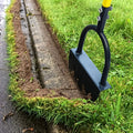 Half-moon lawn edger cutting a border alongside a paved path