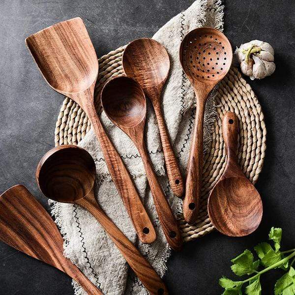 Teak spoons and turners displayed on a woven placemat