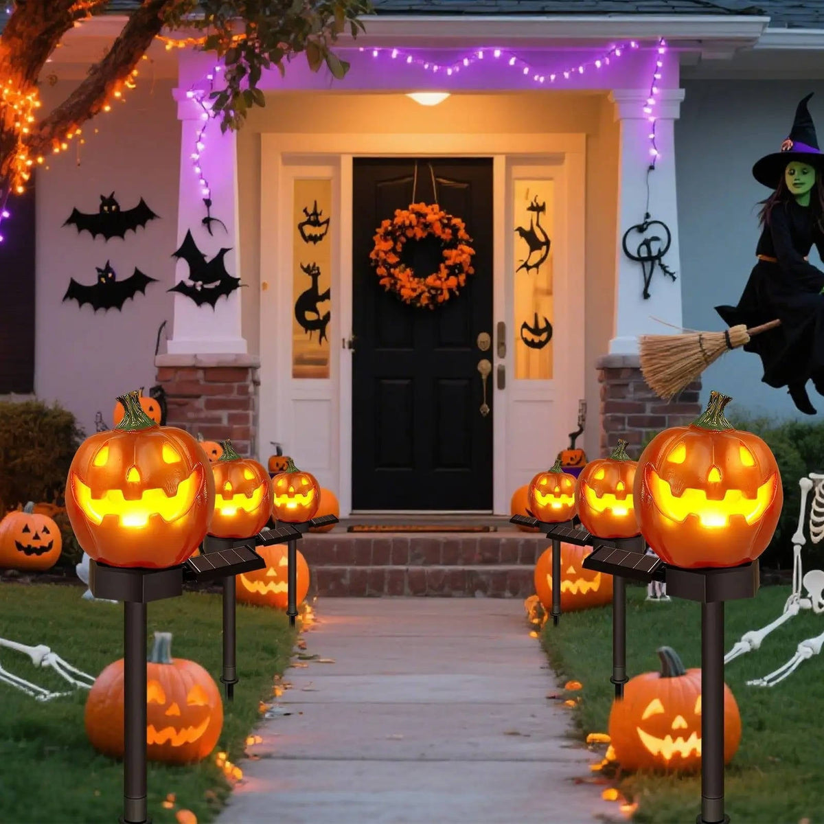 Solar pumpkin stake lights lining a decorated Halloween entrance