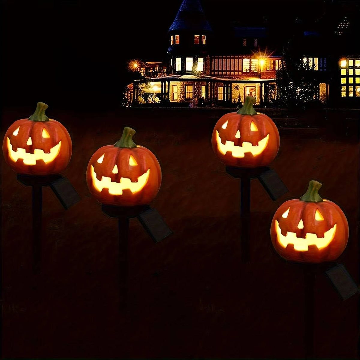 Four illuminated pumpkin stake lights against a dark background