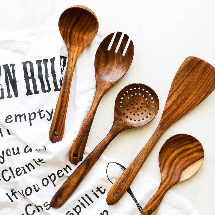 Teak spoons and salad fork displayed on a printed kitchen towel