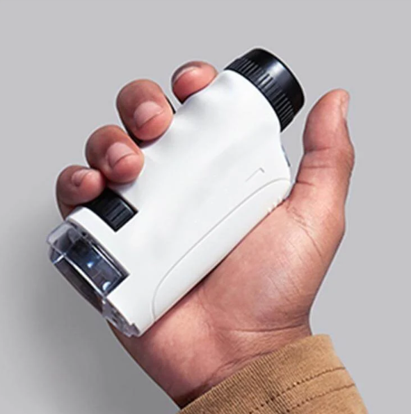 White pocket microscope held in one hand