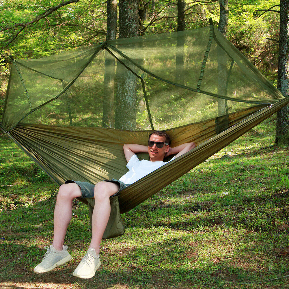 Person reclining in a green hammock with raised mesh net
