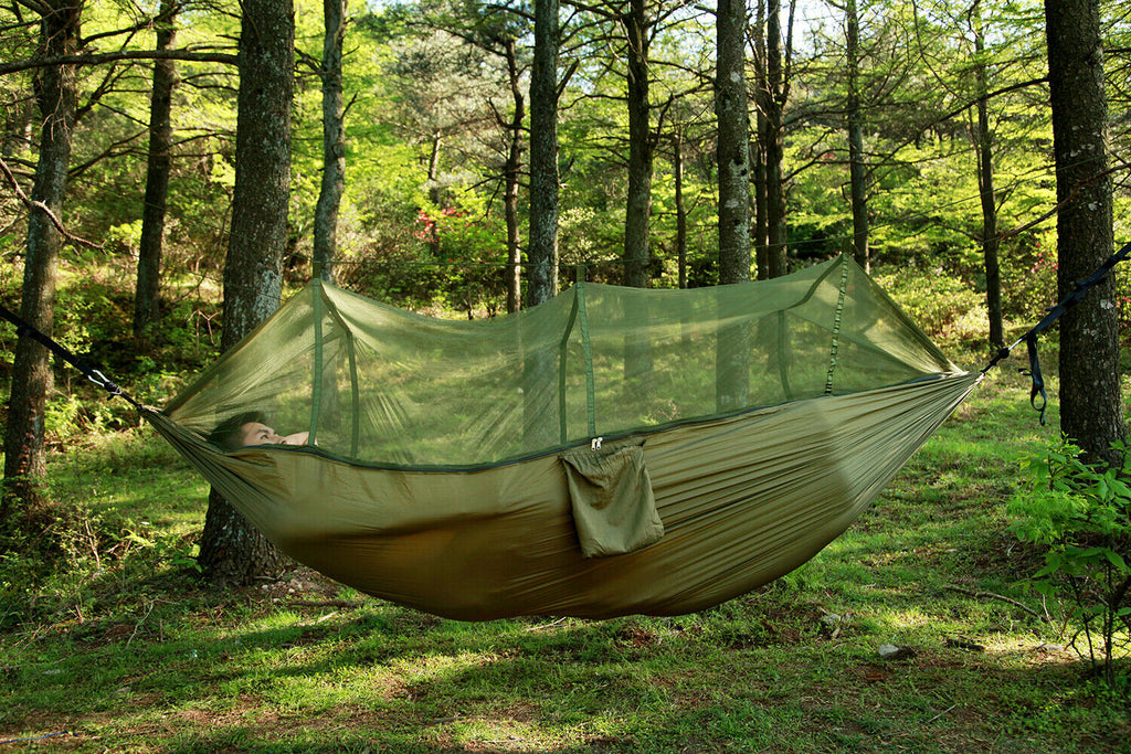 Green hammock with a closed mesh canopy in woodland