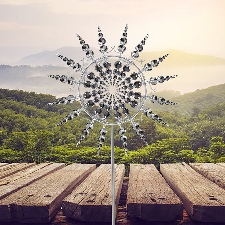 Circular metal wind spinner displayed beside a wooden deck